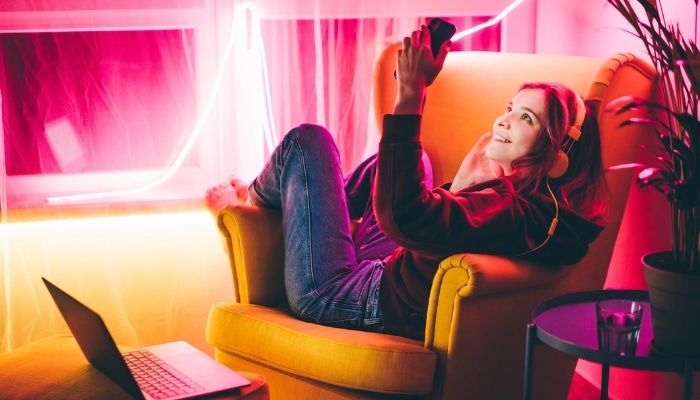 woman with phone in living room surrounded with lights