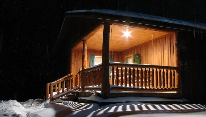 Snow covered home with patio light