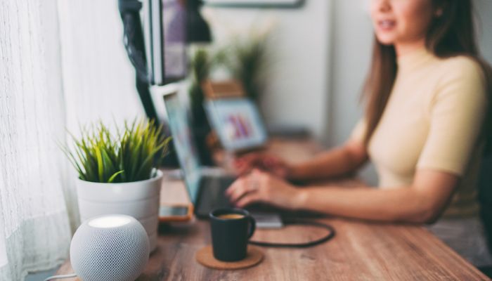 woman working at home talks to virtual assistant