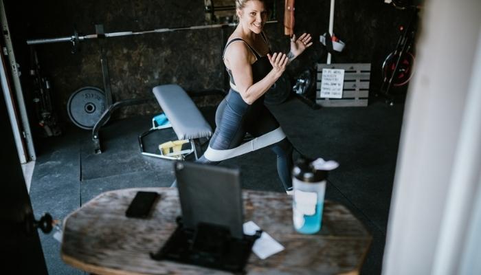 woman using tablet to workout at home