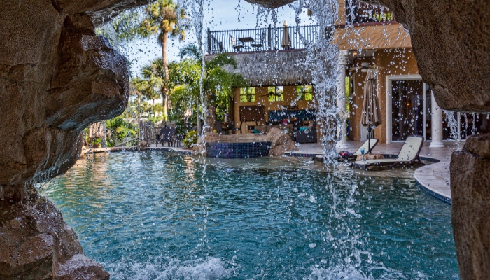 View of a waterfall from a man-made cave in luxury backyard
