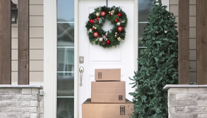 Home with packages on porch and Christmas wreath on door