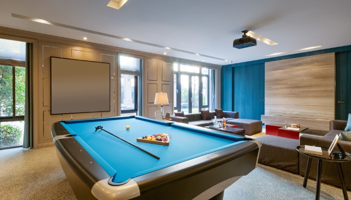 Sports den with projector, comfy seating, and pool table