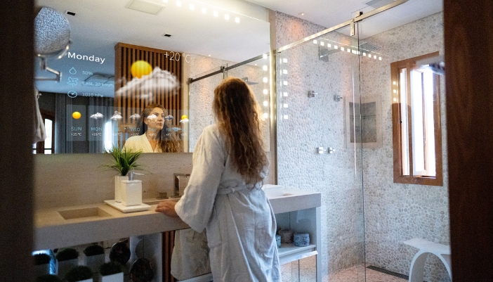 Woman looking into smart mirror and catching up on the forecast and other details in your smart spa