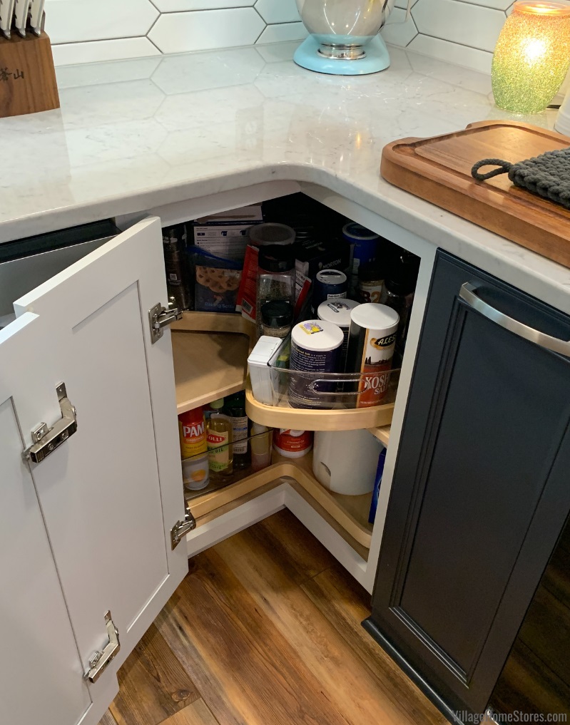 Lazy susan cabinet with door open and tray organizers inside on turning shelves
