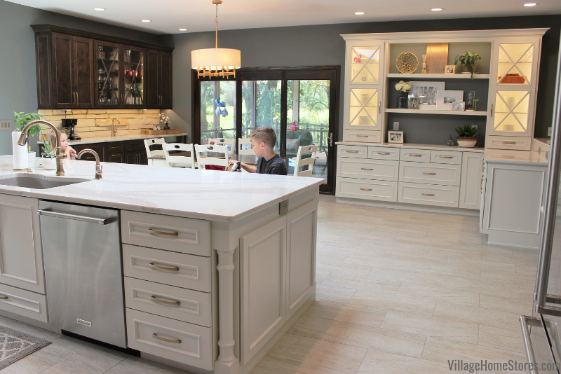 boy seated at kitchen island with hutch and wet bar in background