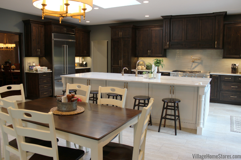 Wood stained custom kitchen with painted white island. Table and chairs in foreground 