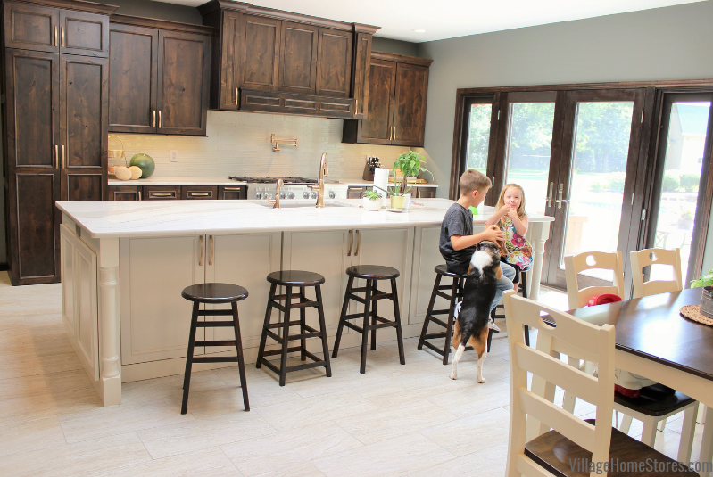 kids and family dog at white painted kitchen island with dark stained cabinets in background
