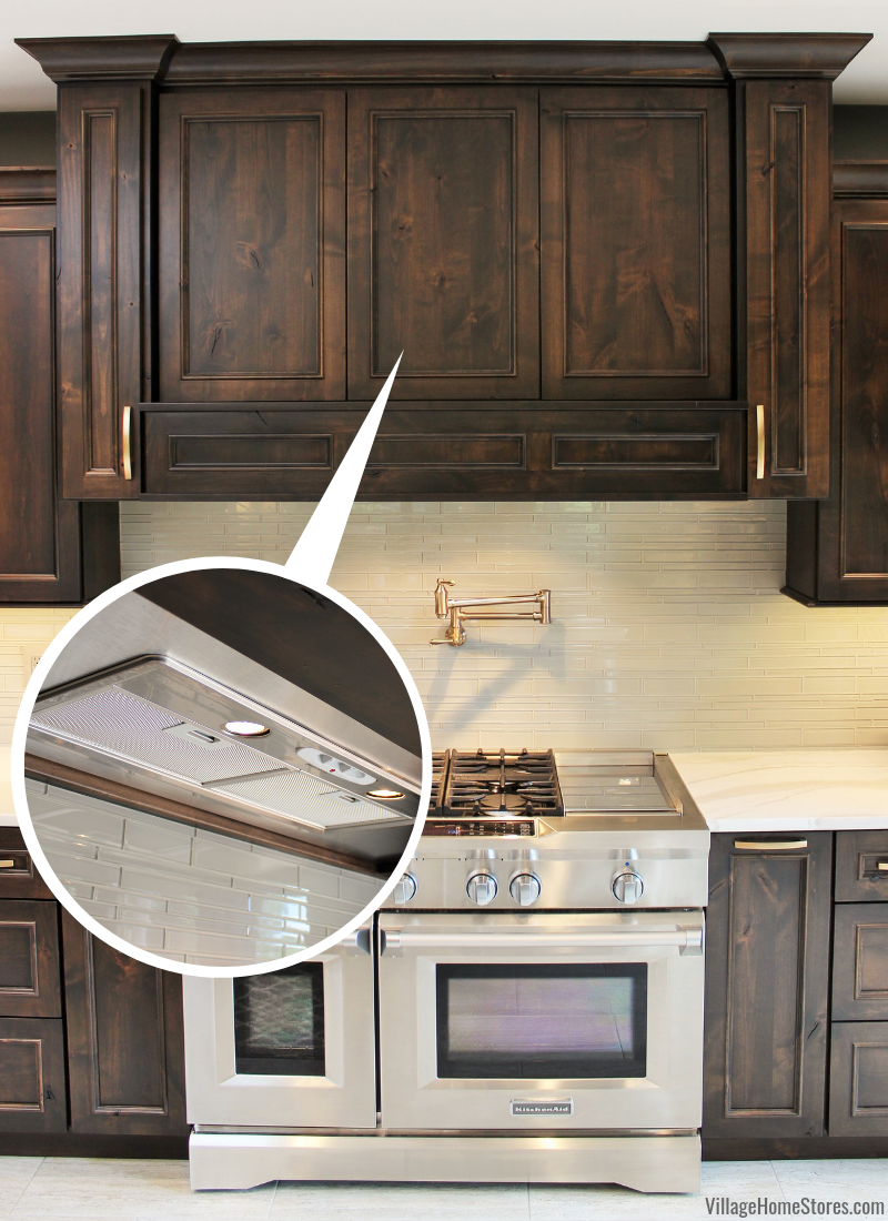 Image with zoomed in image inset showing Broan range hood insert inside of wood hood cabinet.