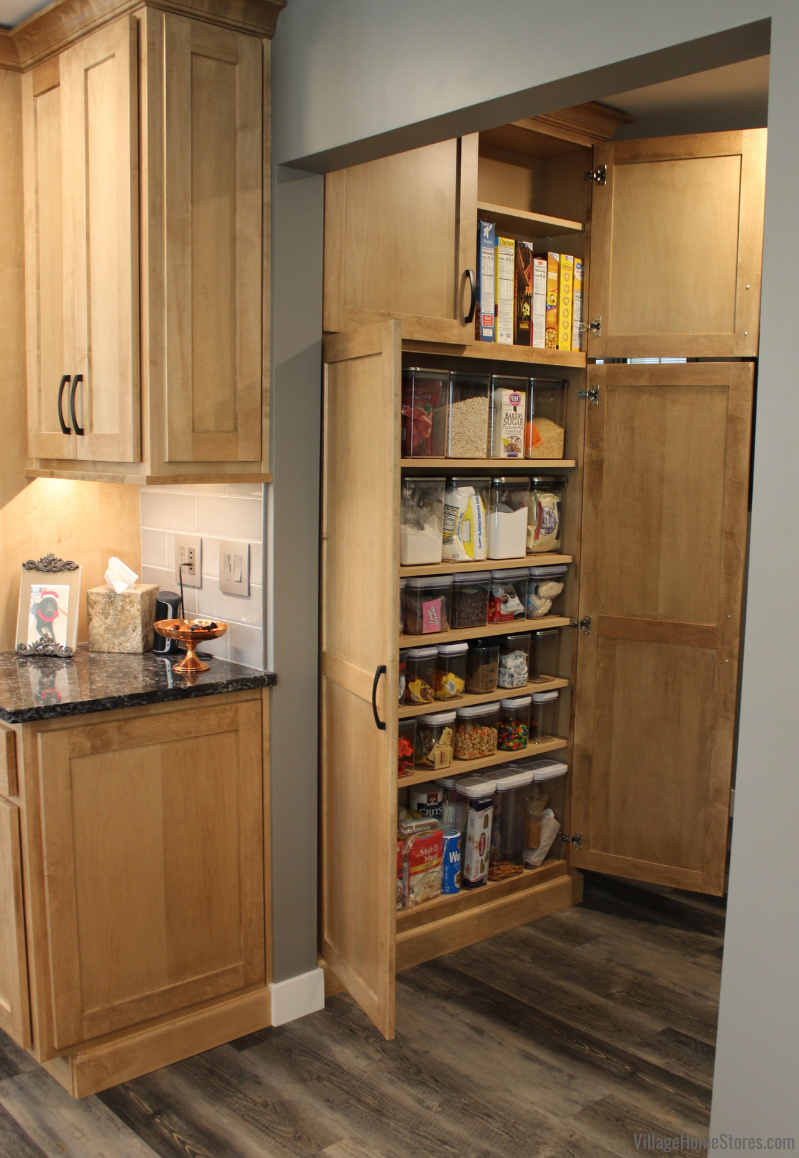 Image showing shallow pantry cabinet located in hallway just outside of kitchen. Doors open with storage containers and cereal boxes