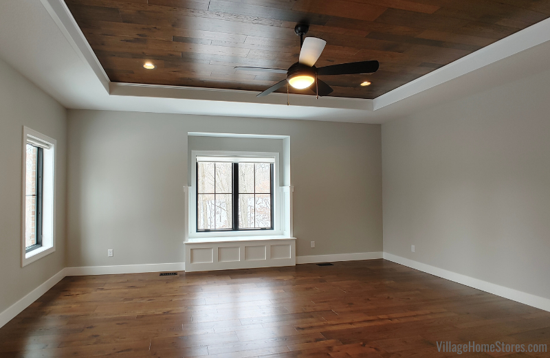 Wood flooring on floors and tray ceiling of a bedroom.