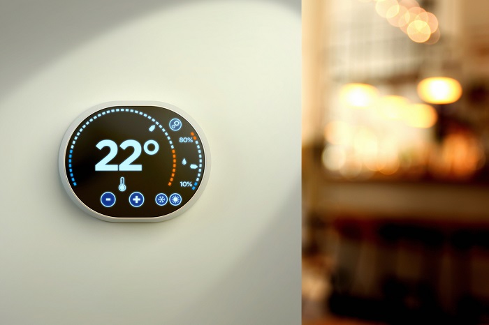 Intelligent home automation system controlling temperature with a touch screen display mounted on a wall. 