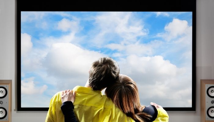 couple embraced looking at a screen of clouds