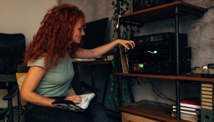 Woman putting in CD to play music on her high-end sound system