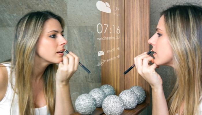 Woman doing makeup in front of mirror TV