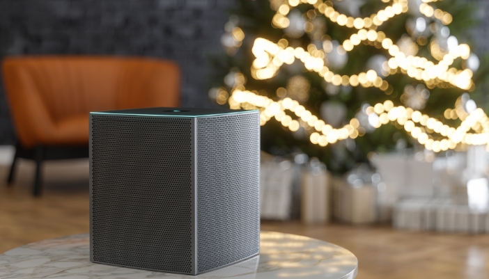 Closeup of a smart speaker in front of a Christmas tree
