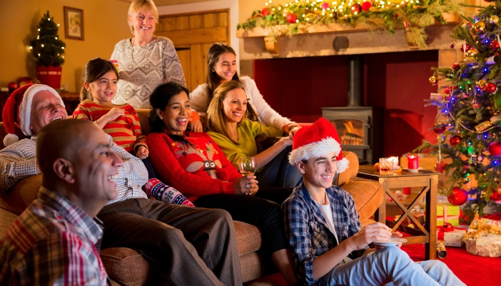 Family gathered around the living room TV during holiday party