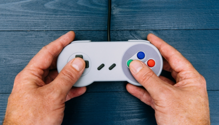 Closeup of a pair of hands playing a vintage game controller