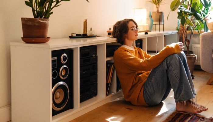 Woman listening to home sound system with speakers, receivers, and amps