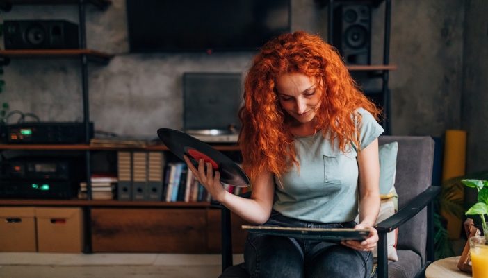 Woman holding a vinyl record and reading the line notes
