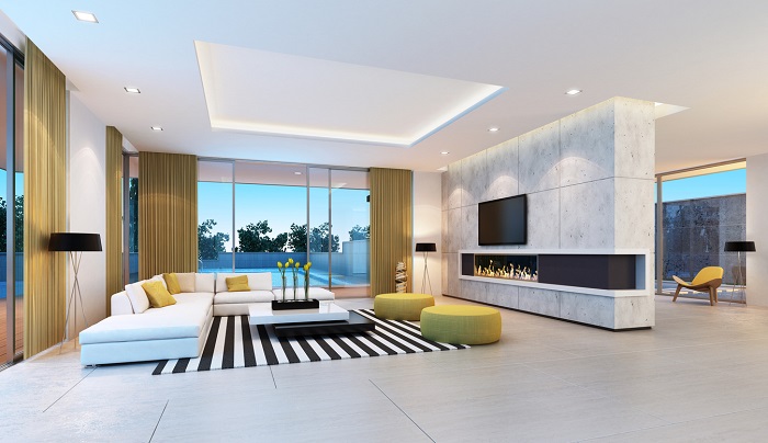 Contemporary living room of a luxury home with overhead lighting and large marble wall. 