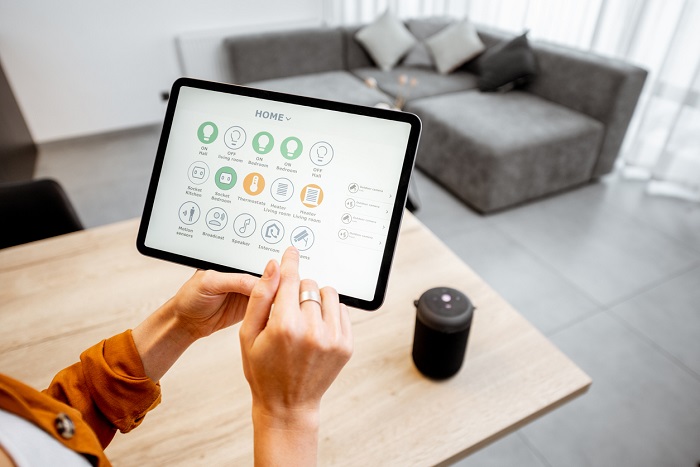 Young woman controlling home with a digital touch screen panel.