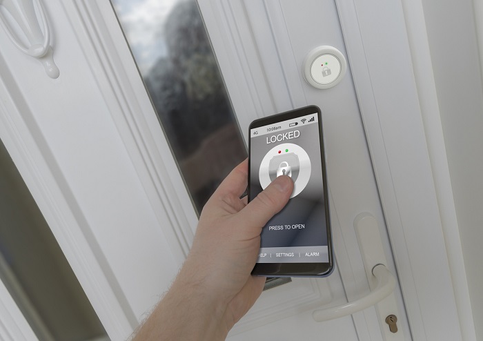 Using a smartphone to open a smart lock on a front door. 