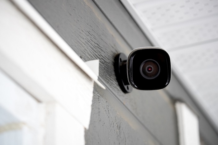 Black security camera outside of a home.