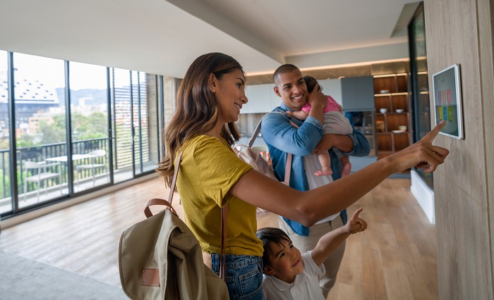 Happy family leaving the house locking the door using automated security system.