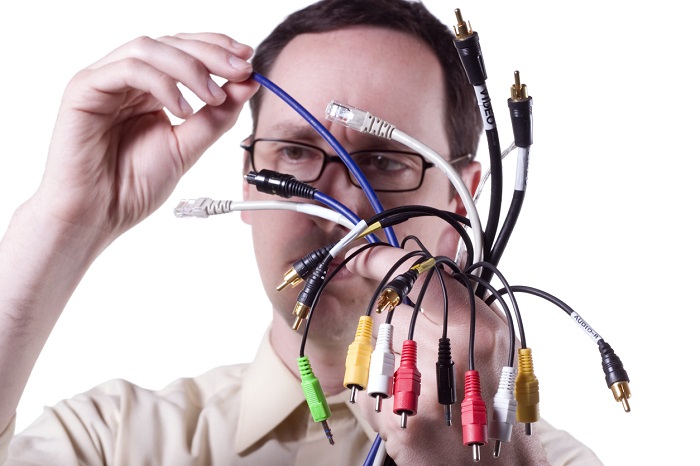 Man warily examines a handful of cables