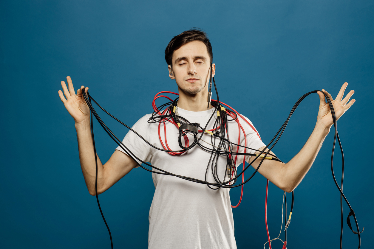 Young man draped in tangled cables