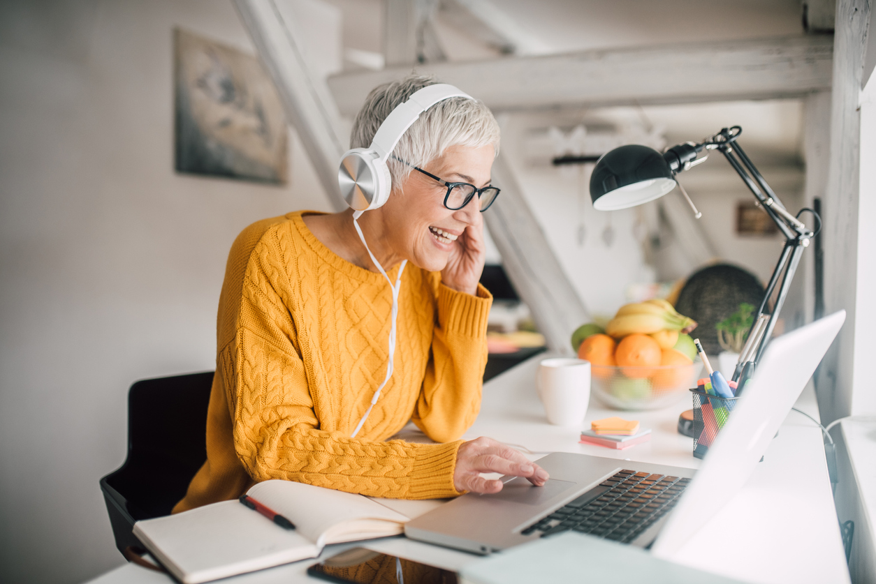 Woman does business in her home office with over-the-ear headphones on