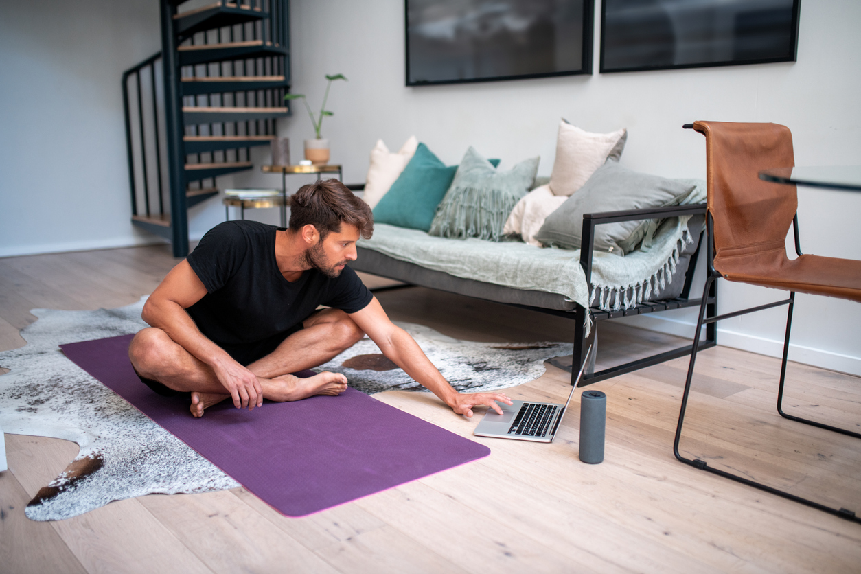 Man gets ready for yoga at home with a portable speaker setting the mood