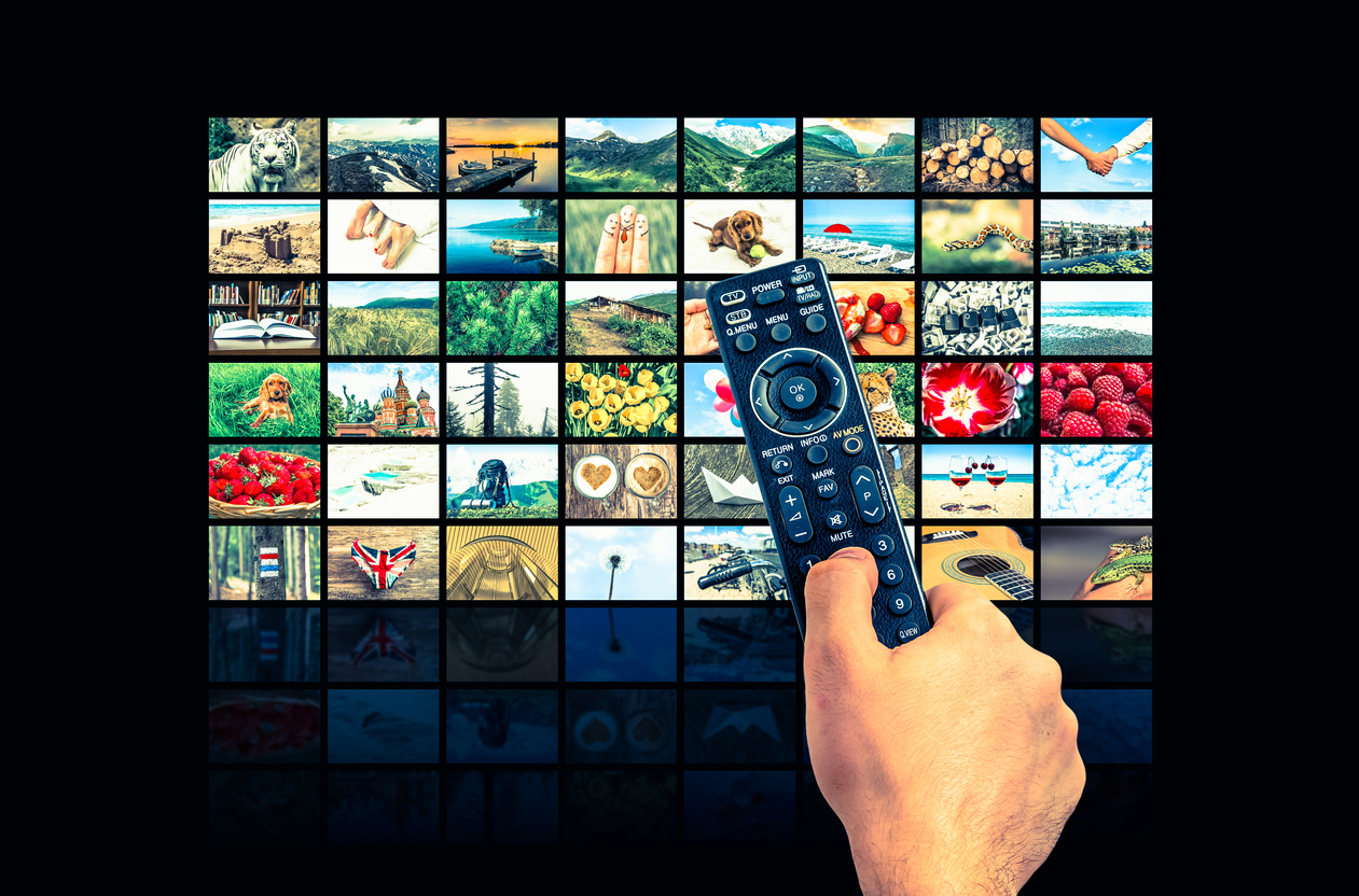 Photo collage on an HD TV screen with a hand holding the TV remote control 
