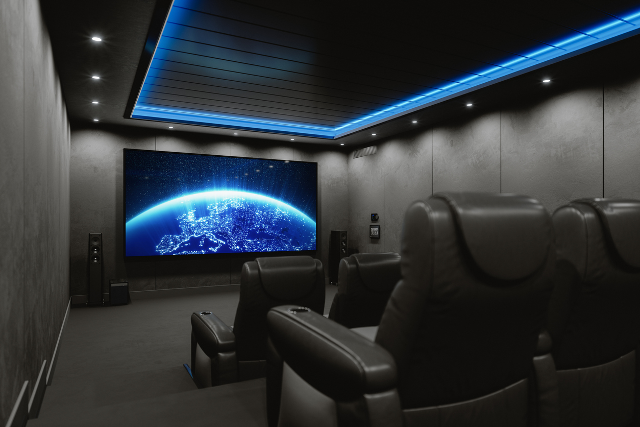 Leather home theater seating faces a large screen in a fully customized home theater