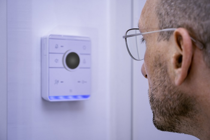 Man standing in front of smart doorbell system.