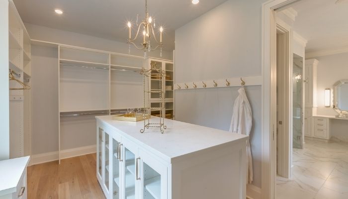 walk-in closet with chandelier and island