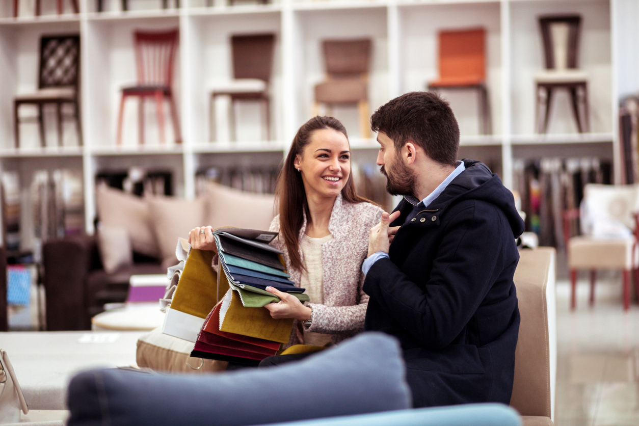 couple at a furniture store choosing fabrics for new couch