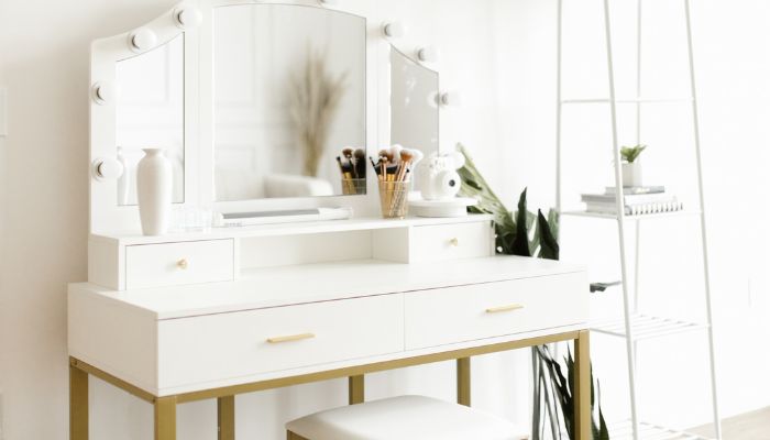 Empty white vanity table with makeup brushes and drawers