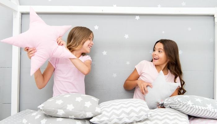 Two girls having pillow fight