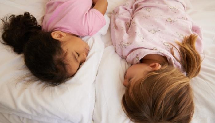 Two kids sleeping facedown