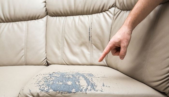 finger pointing to sofa damaged leather