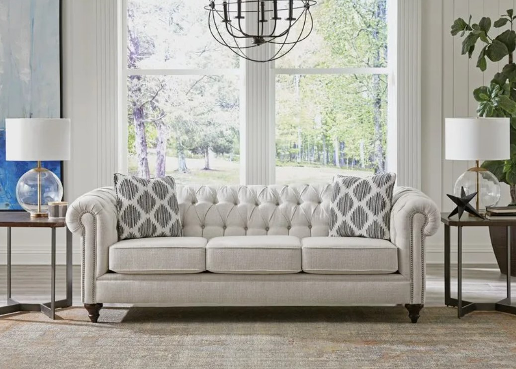 Chesterfield grey sofa between two accent tables in a high end living room