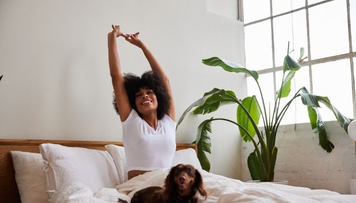 woman waking up happy with dog