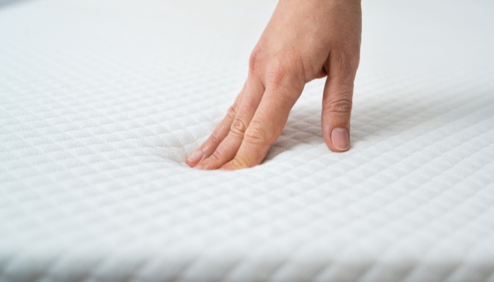 Hand touching mattress