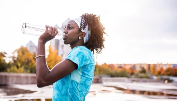 Woman hydrating with bottle of water