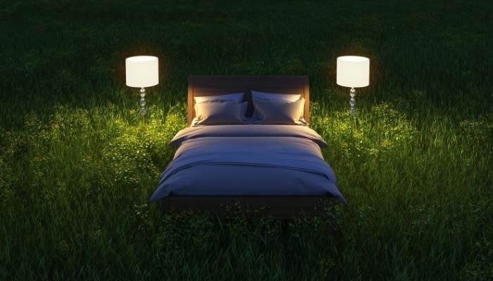 Mattress surrounded by grass in the middle of the night