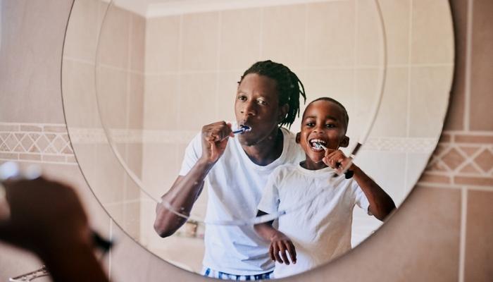 father and son brushing their teeth before bed.