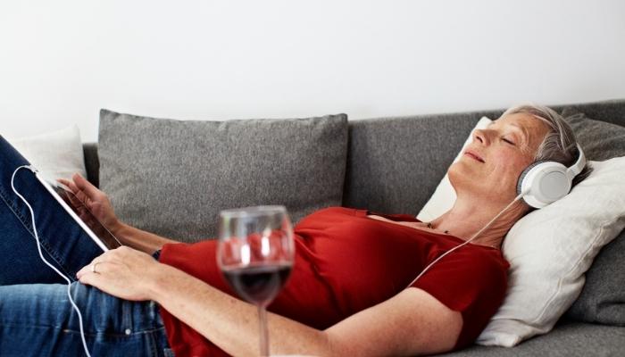 woman lying on her sofa with glass of wine
