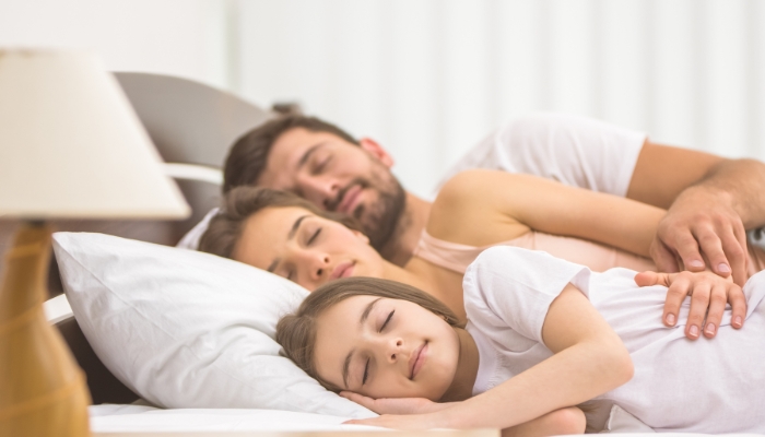 Happy family sleeping on a large mattress